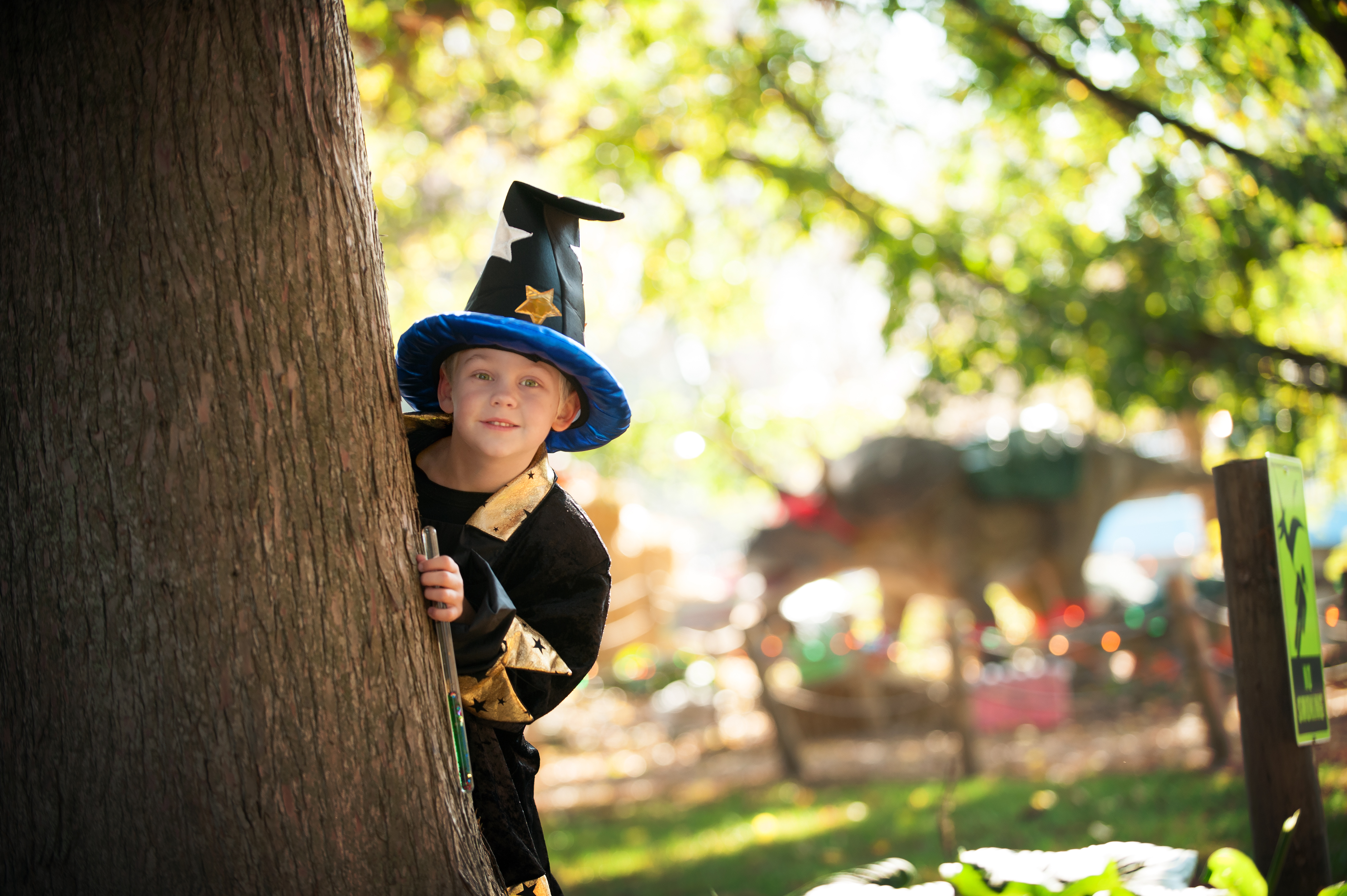 Child hiding behind tree